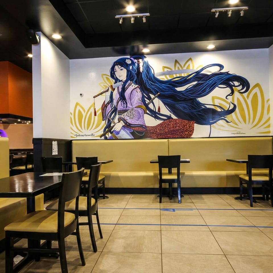 Restaurant dining area with yellow booths, dark tables, black chairs, and a large anime-style mural of a sword-wielding woman.